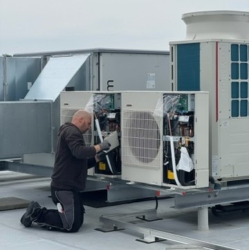 Ein Mann verbaut einen Verflüssiger.